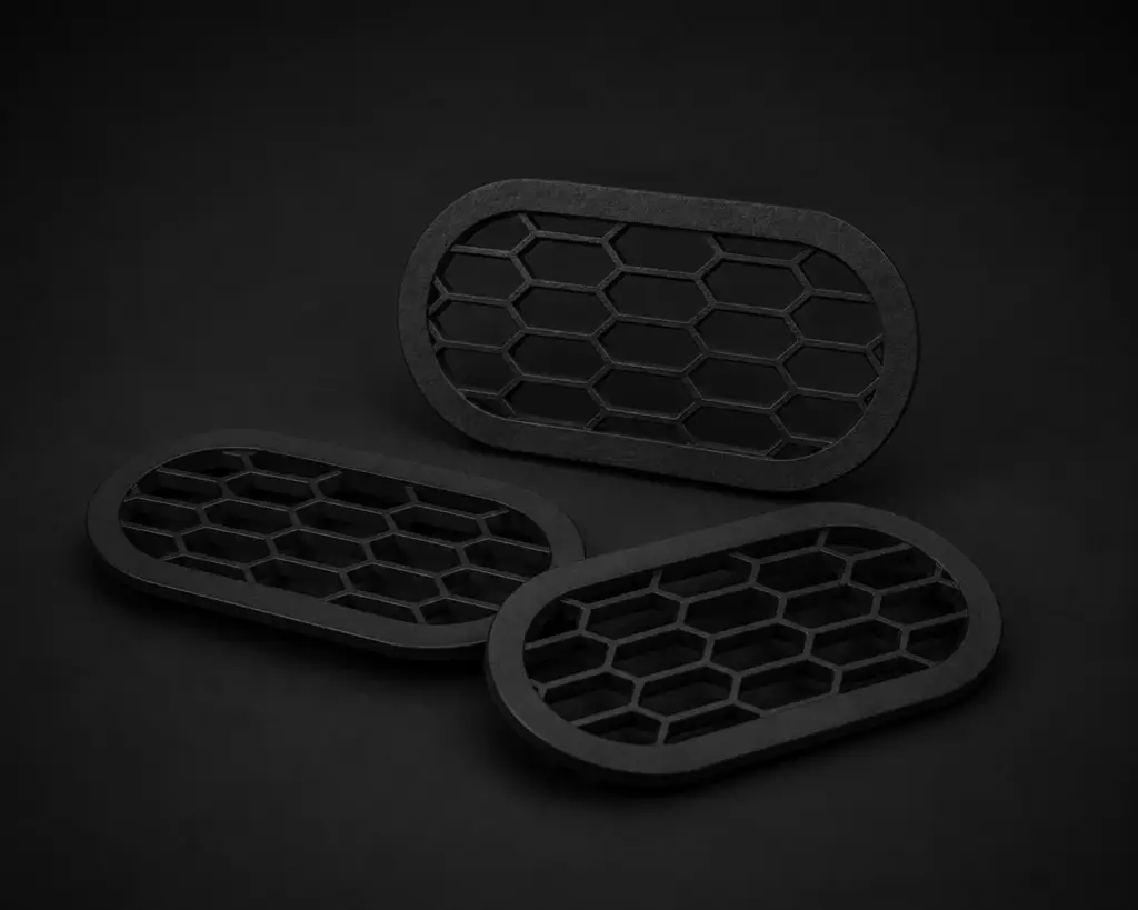Drei schwarze Rear Bumper Vents mit Wabenstruktur auf dunklem Studiohintergrund